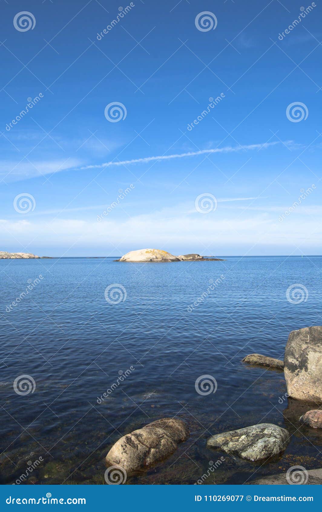 Fotografía hermosa del específico de la estación de verano Cantos rodados y rocas grandes así como colores ricos del azul/del infante de marina/del océano de la turquesa Luces y colores preciosos del verano Ambiente del infante de marina y del océano en verano