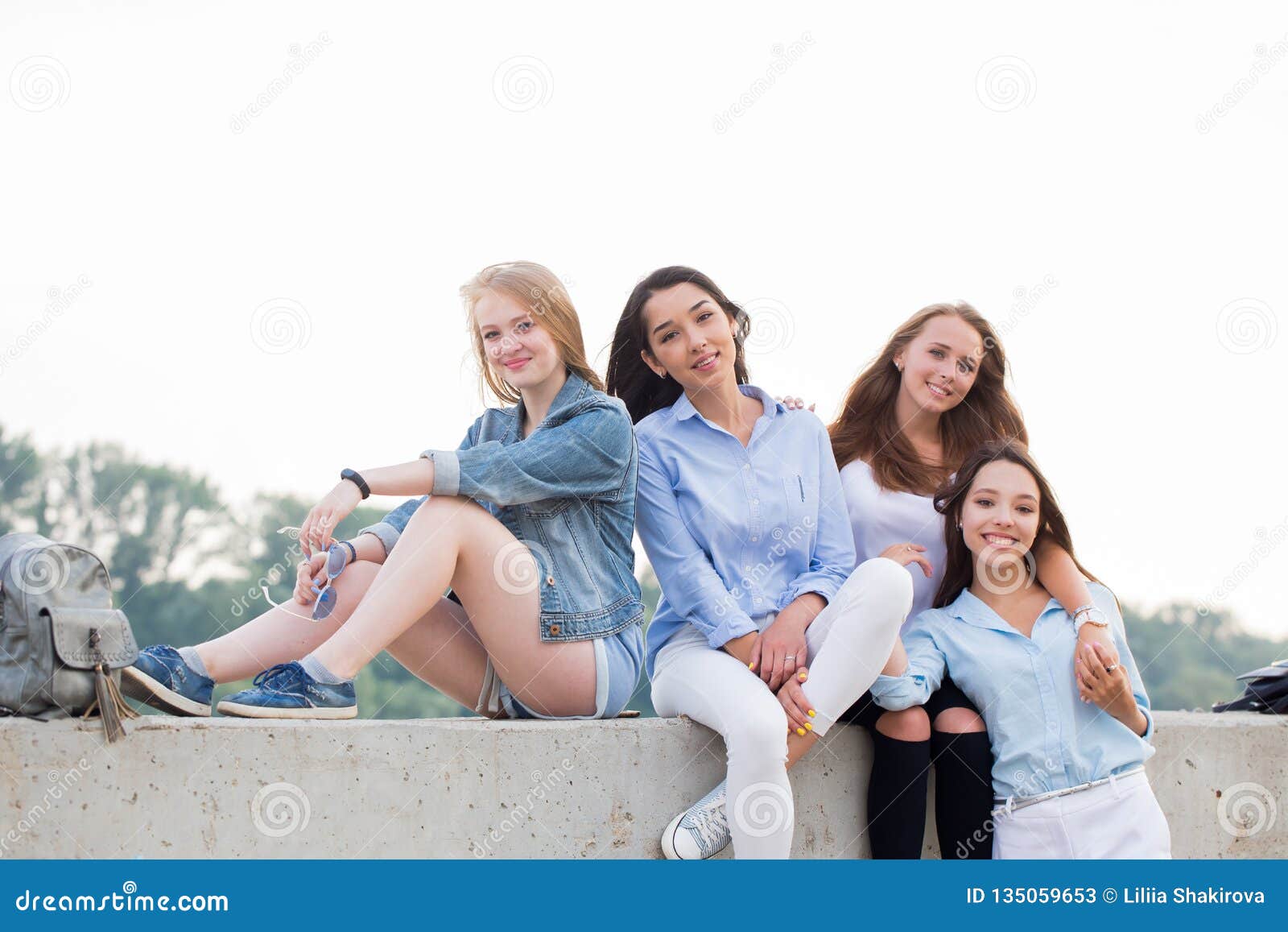 Four Attractive Happy Cute Female Friends Sitting in Nature and ...