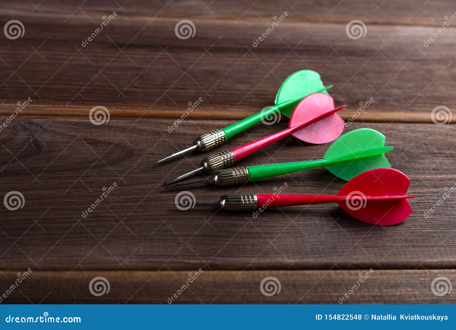 Four Colored Darts on a Wooden Background. Hit the Target Stock Photo ...