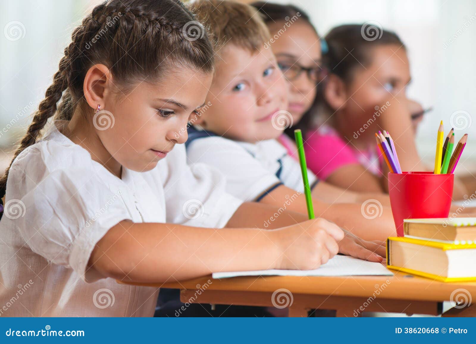 four diligent pupils studying at classroom