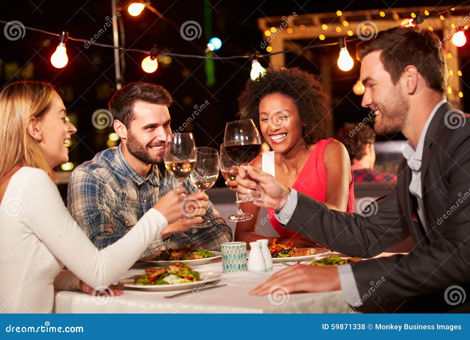 Four Friends Eating Dinner at Rooftop Restaurant Stock Photo - Image of