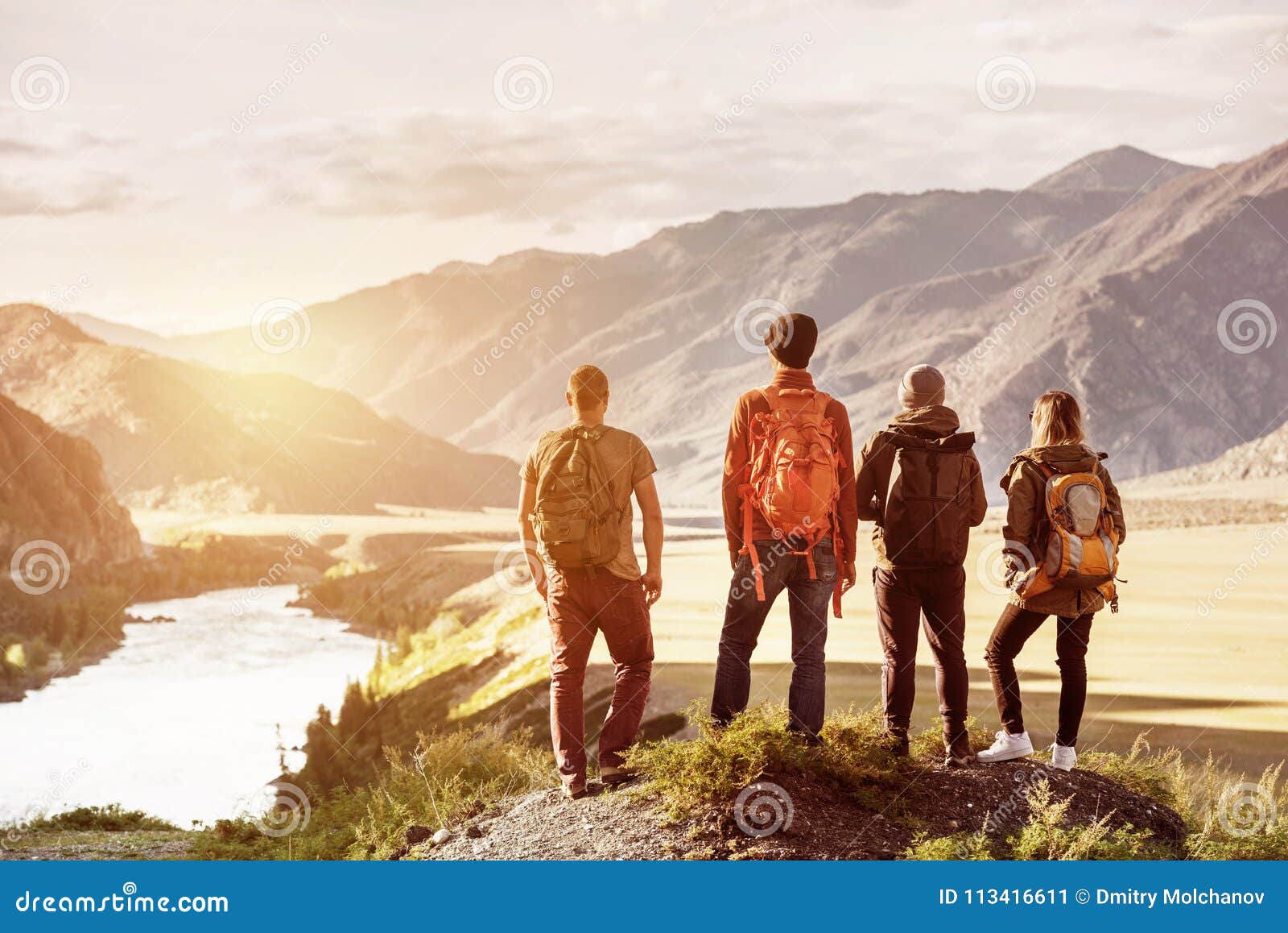 four friends sunset mountains travel concept