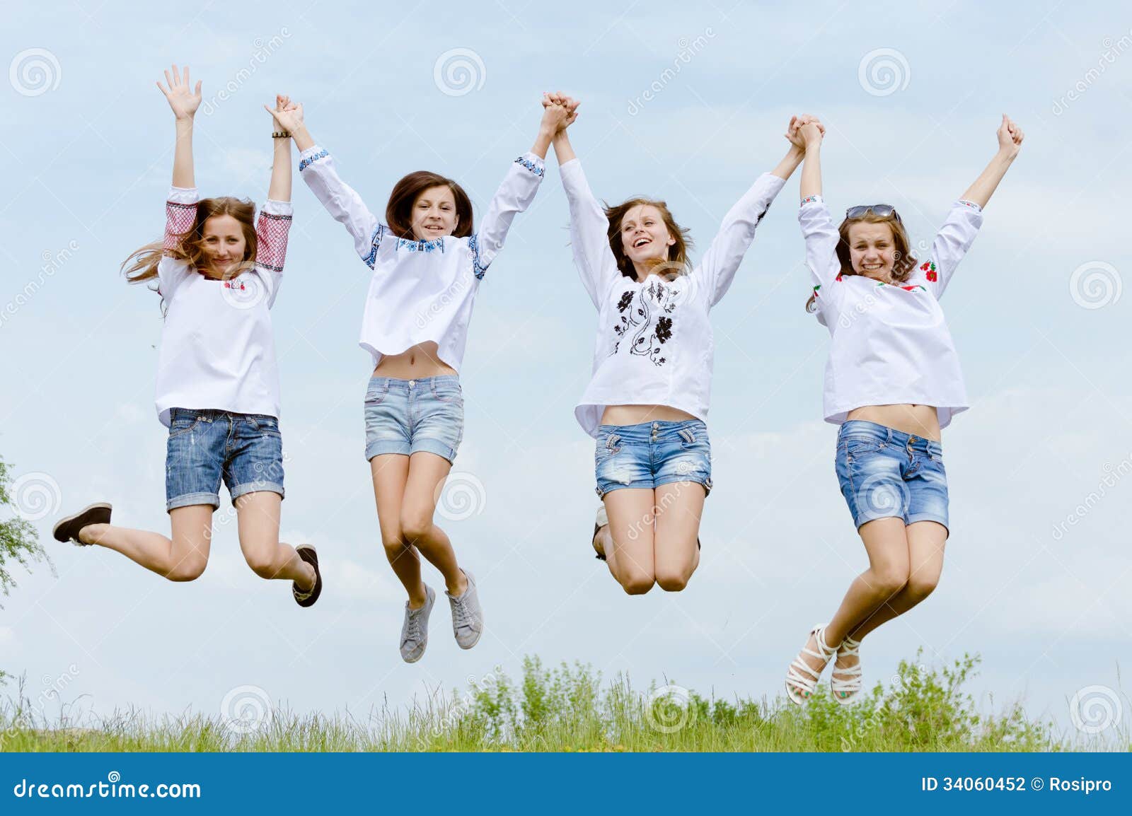 Four Happy Girl Friends Jumping High in Blue Sky Stock Photo ...