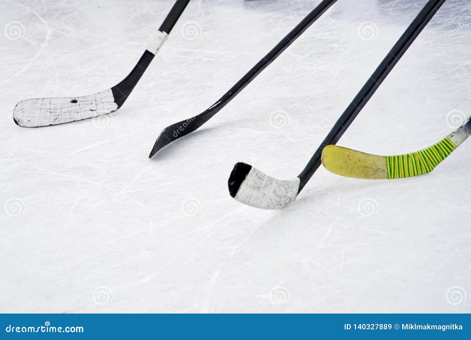 Four Ice Hockey Sticks On The Ice Preparation For Training In An