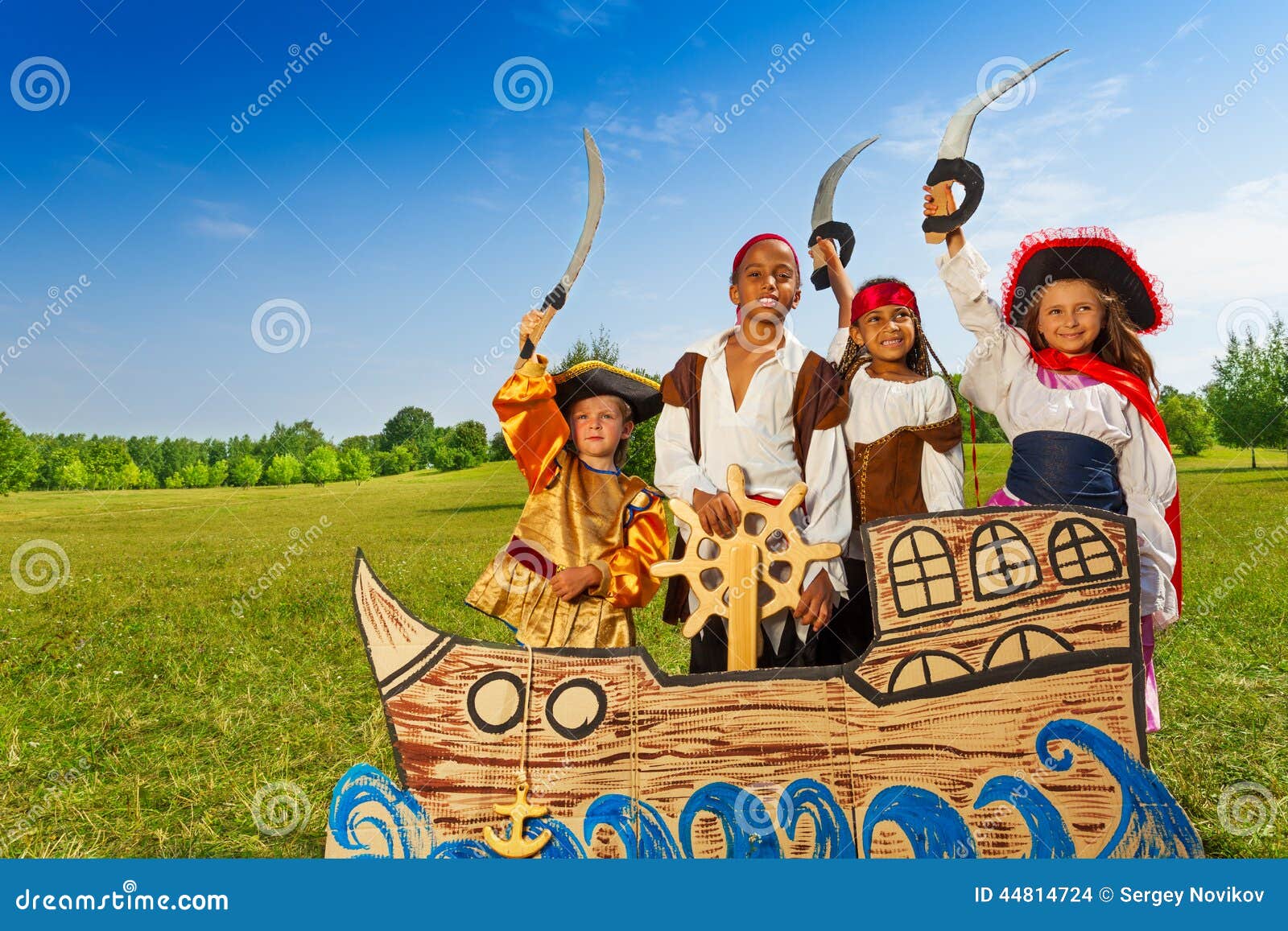 four kids in pirate costumes behind ship