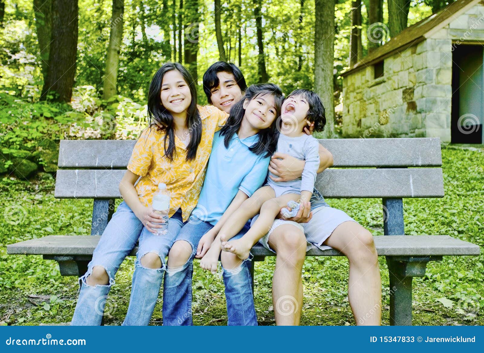 Four kids sitting on bench stock image. Image of four 15347833