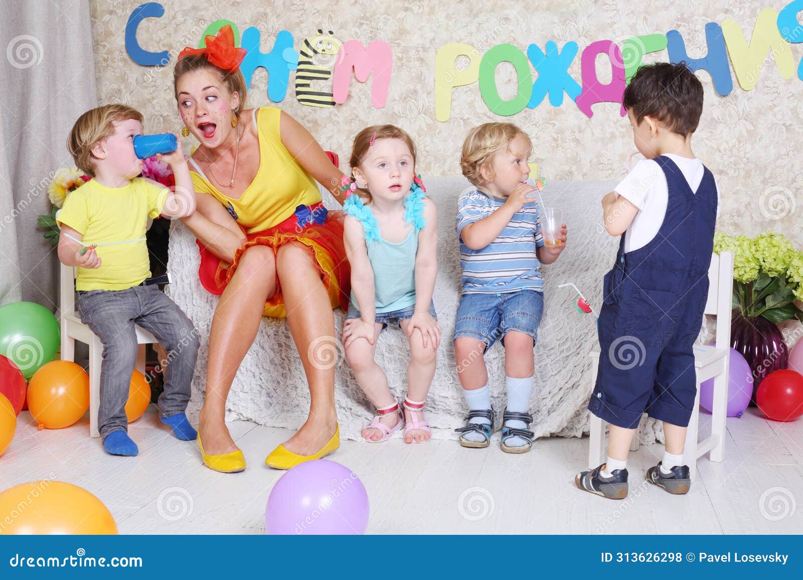 four little kids with juice and entertainer sit on