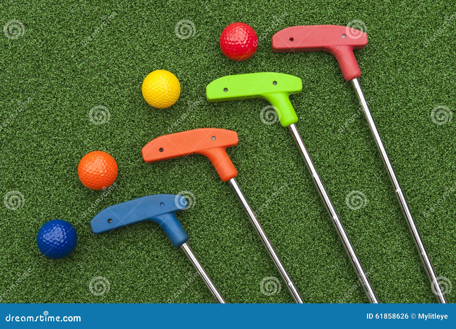 four mini golf putters and balls