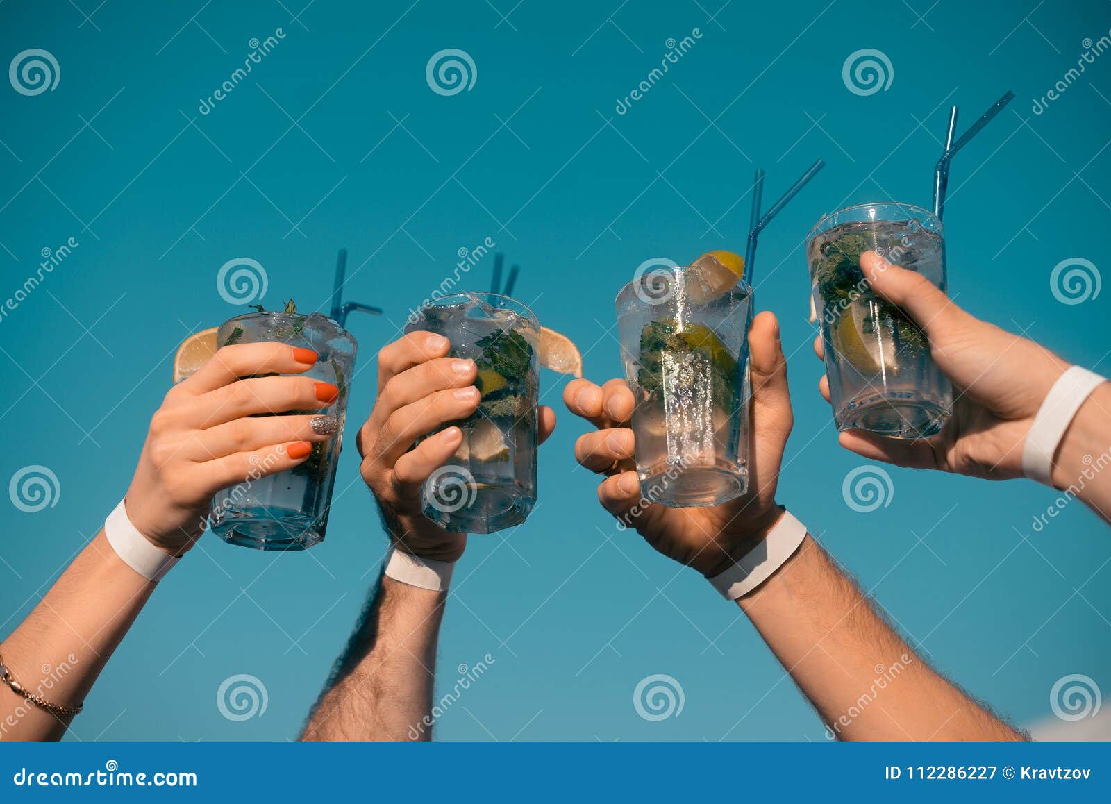 Four Mojito Cocktails in Hands on the Sky Background Stock Image
