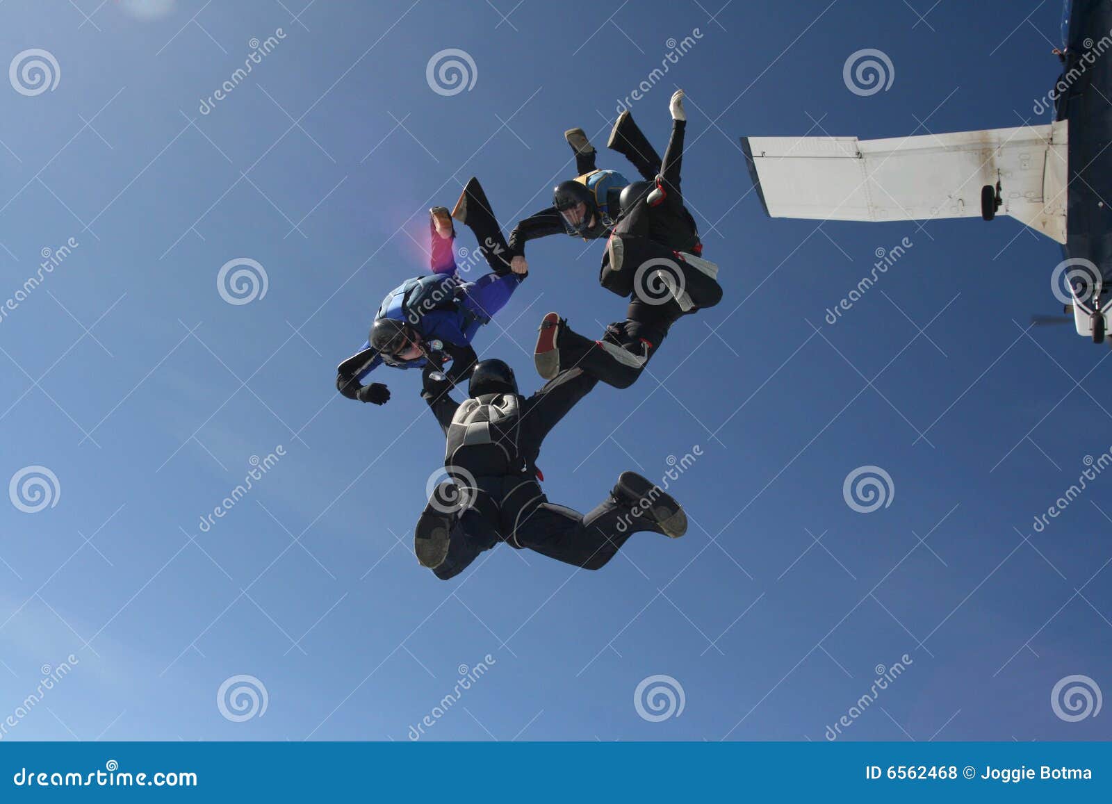 four skydivers exit a plane