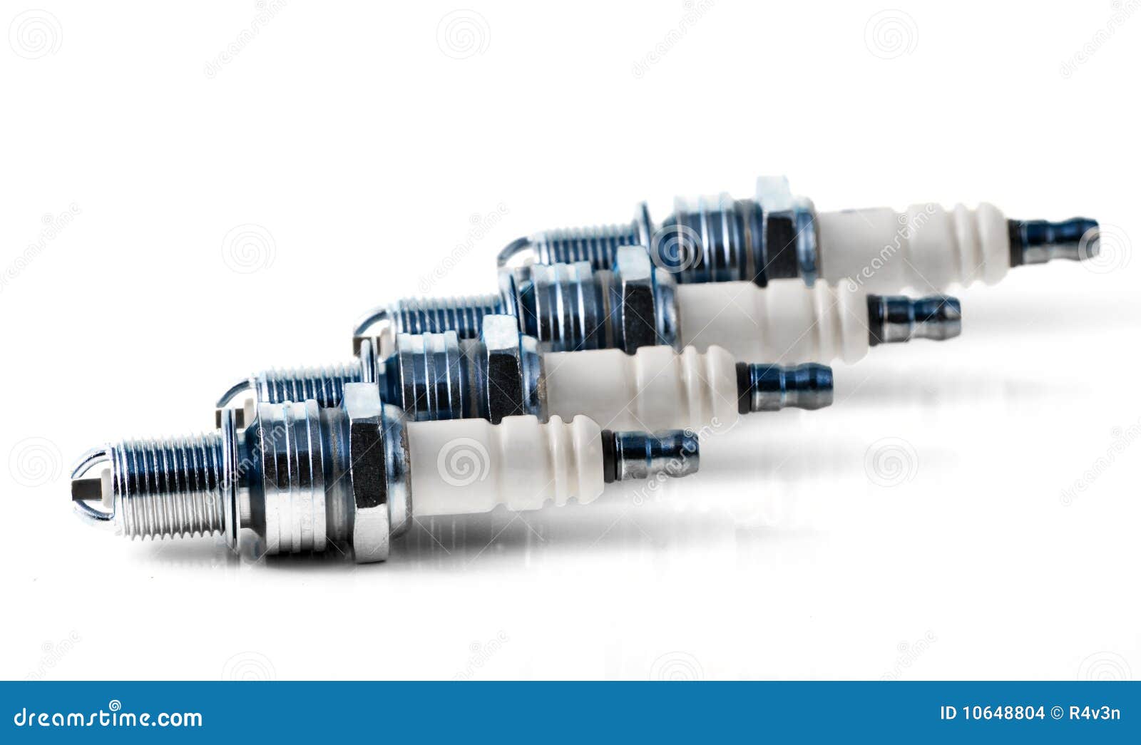 Four spark plugs for car s engine isolated on white. Small DOF. Macro.