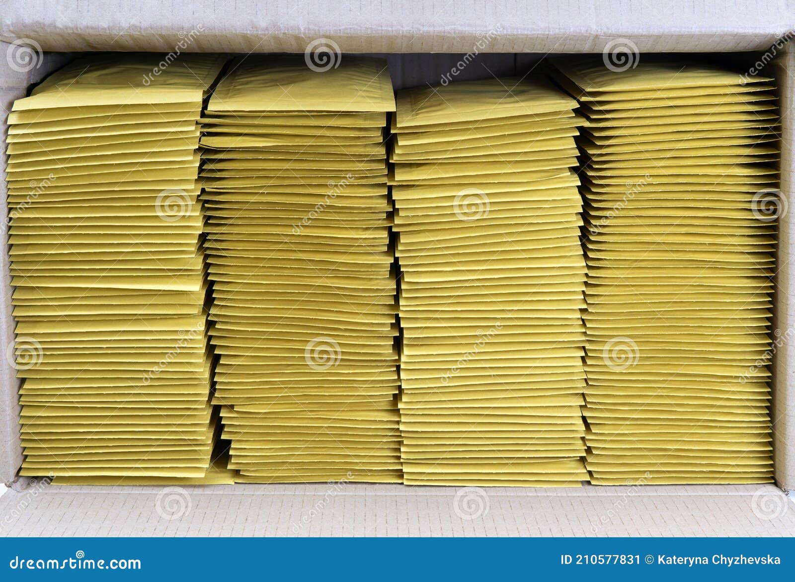 Four Stacks of Yellow Mailing Envelopes in a Shipping Box Stock Image
