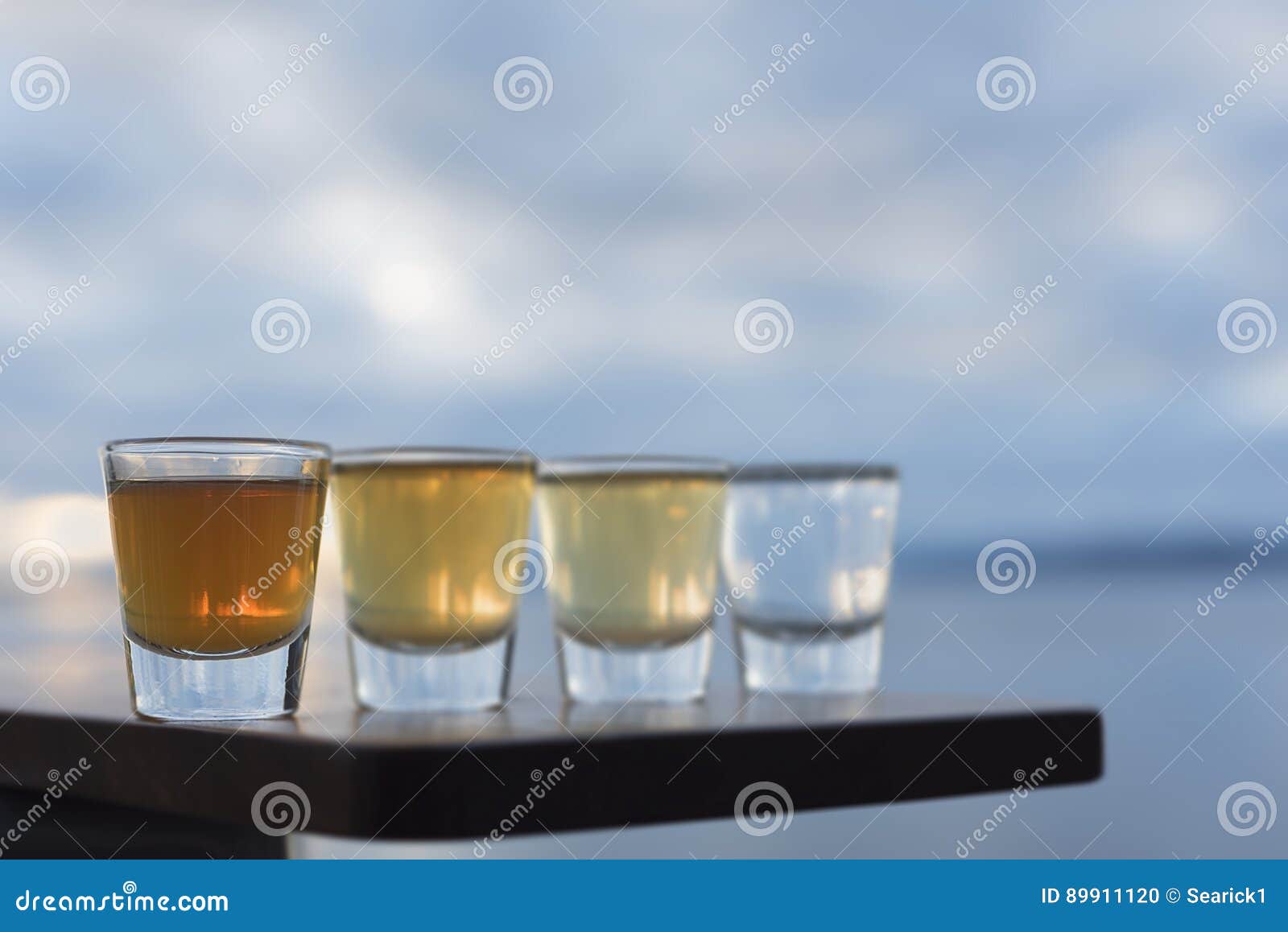 Four Types Of Tequila Shots Lined Up On Seaside Deck RoyaltyFree Stock