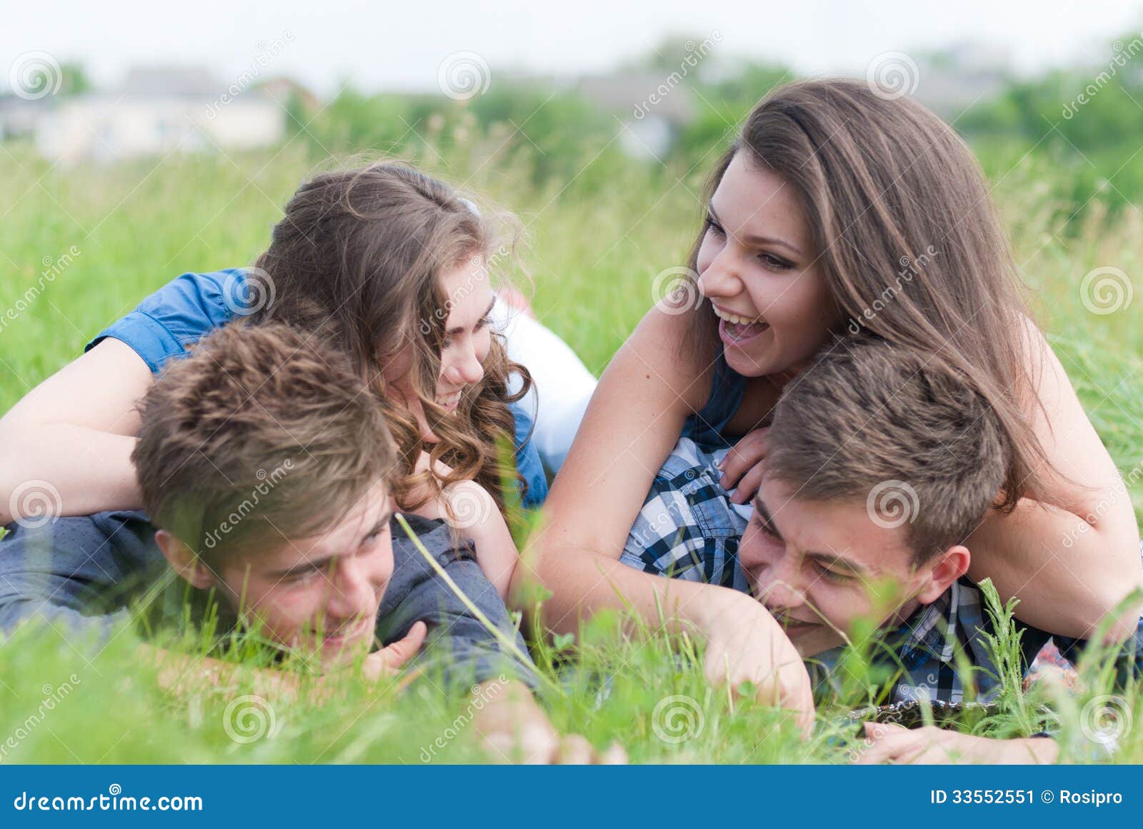 Four Young People Friends Lying Together on Green Grass Outdoors ...