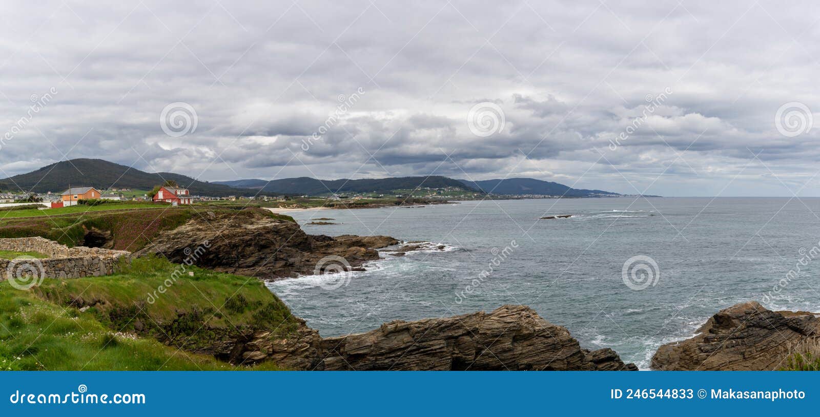 coastline in galicia near foz with green meadows and homes on the seashore