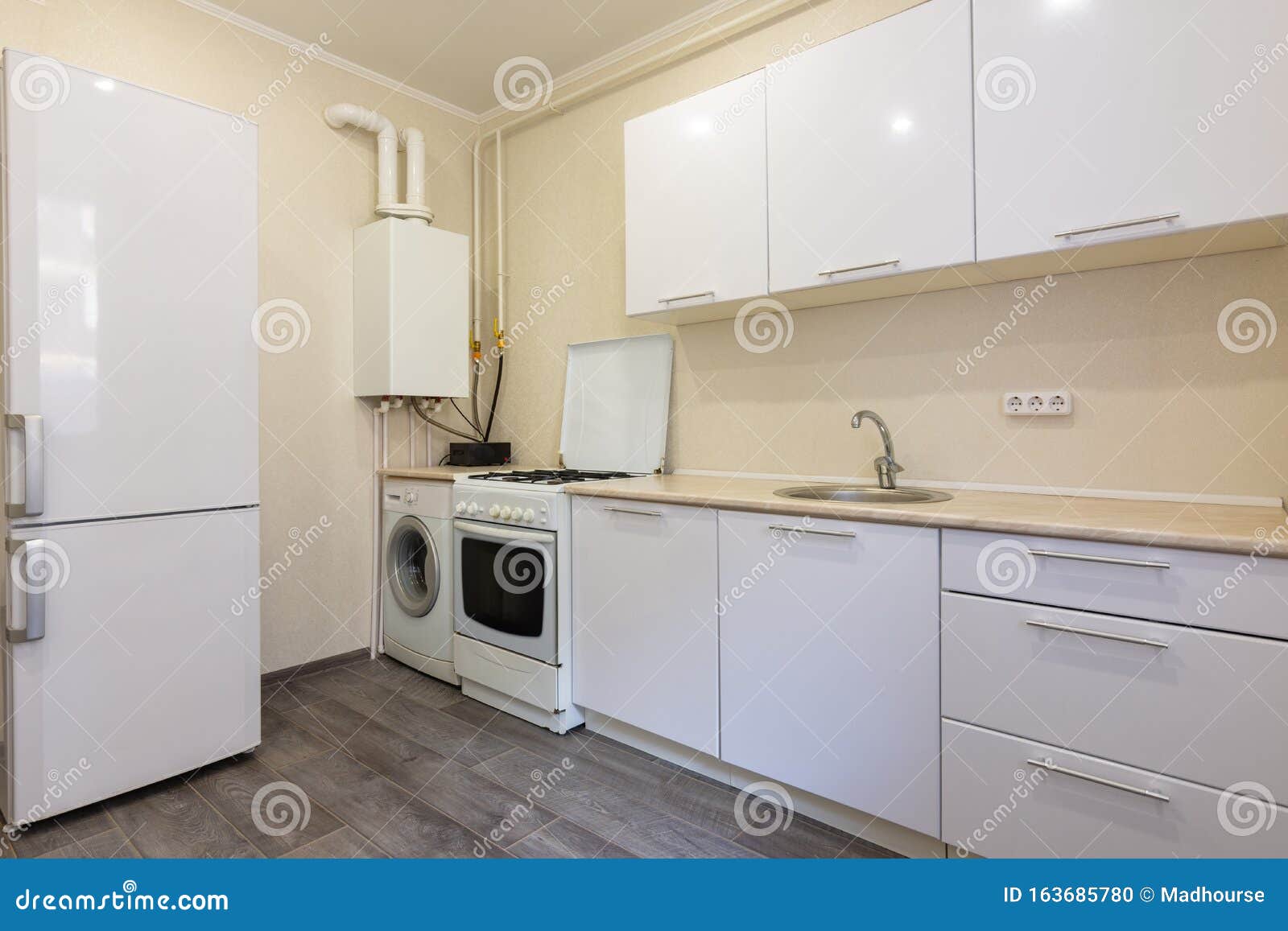 fragment of the interior of a small kitchen with a fridge and a kitchen set