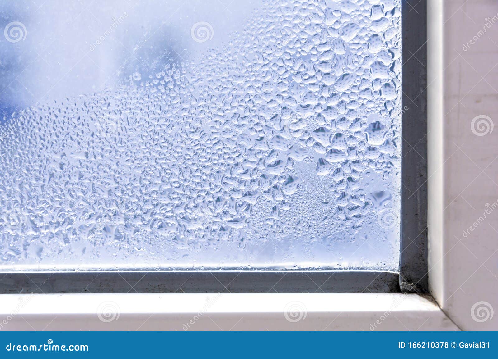 a fragment of a plastic window with condensation of water on the glass. concept: defective plastic window with condensation,