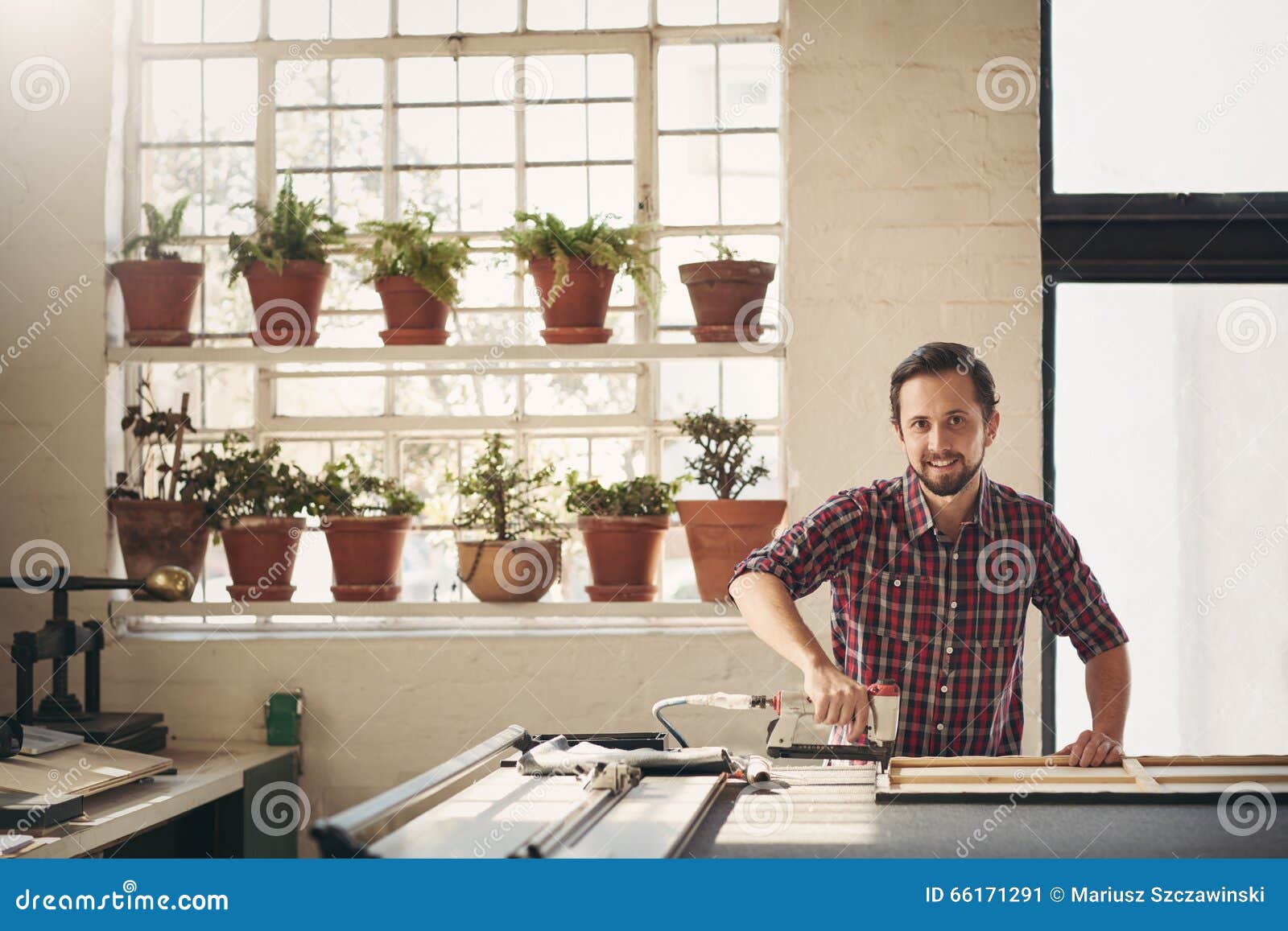 framer in his studio working with a tool on workbench