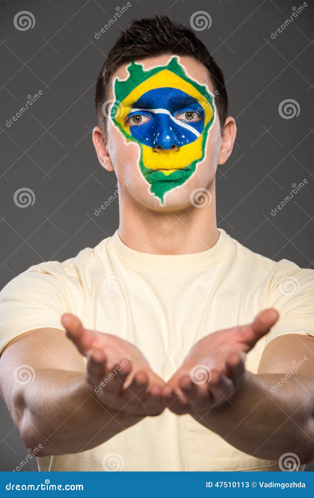 Framsidakonst Bodypaint Flaggor. Ståenden av den unga mannen med den brasilianska flaggan målade på hans framsida