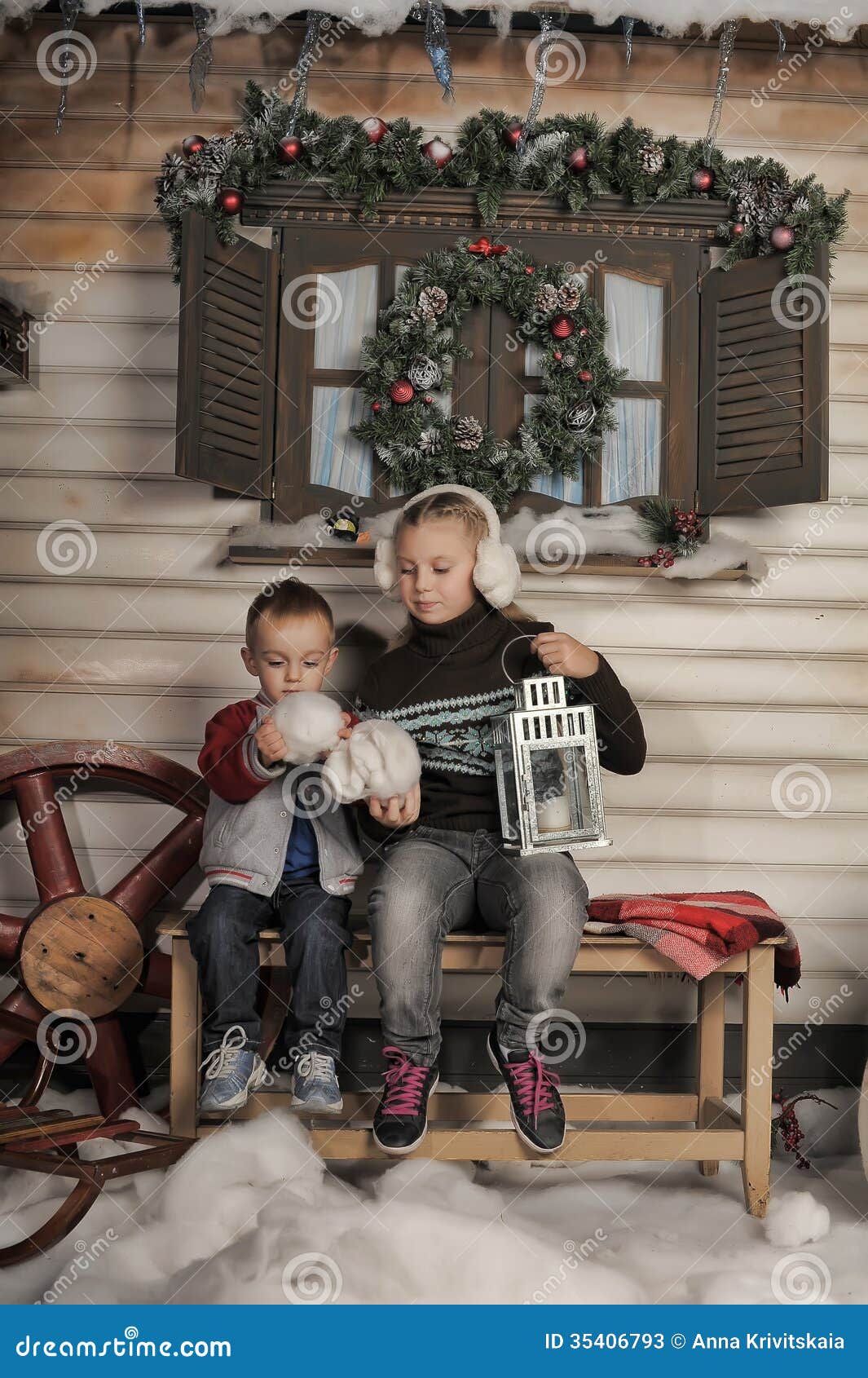 Fratello e sorella su un banco davanti alla casa nell'inverno nel Natale