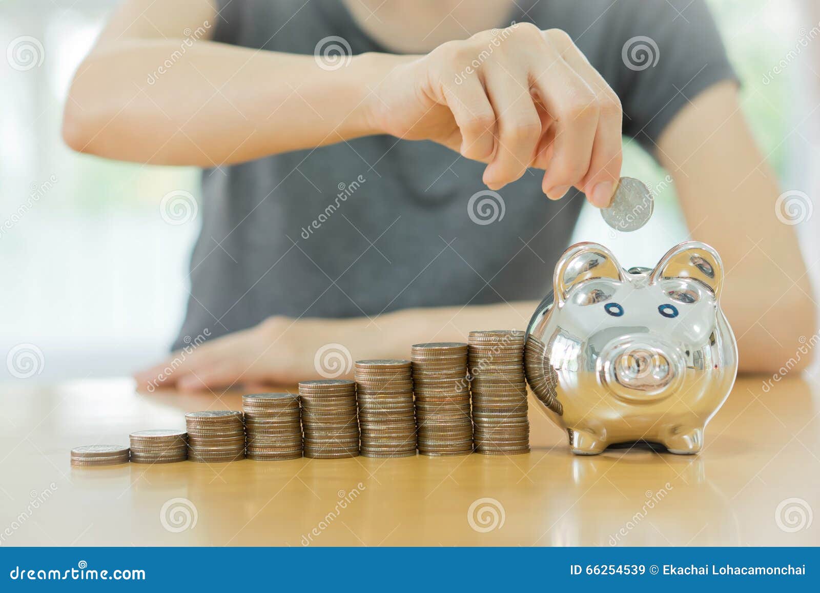 Frau, die eine Münze in einen Geld-Kastenabschluß u setzt. Speichernde geld-junge Frau, die eine Münze in einen Geld-Kastenabschluß aufstellt