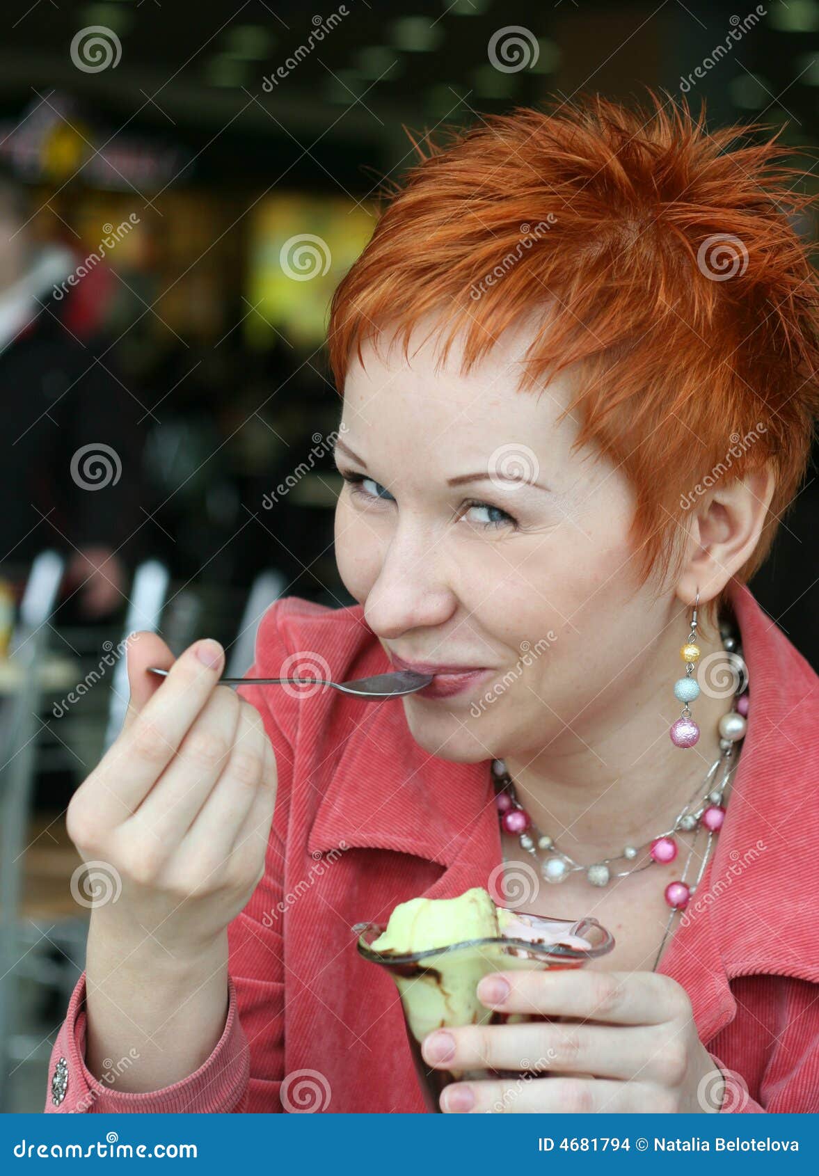 Frau, die Eiscreme isst. Frau, die Eiscreme im Kaffee und das Lächeln glücklich isst