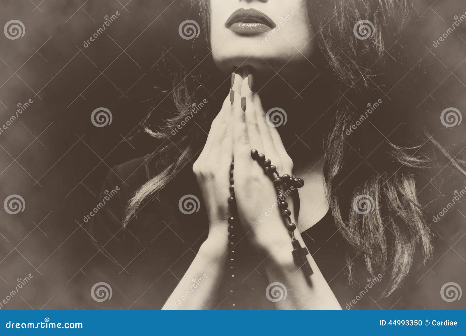 Frau, die mit einer Retro- Weinlese Rosenbeet Sepia betet