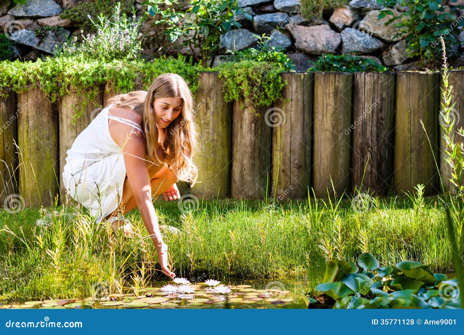 Frau, Die in Teich in Ihrem Garten Sitzt Stockfoto Bild von kleid