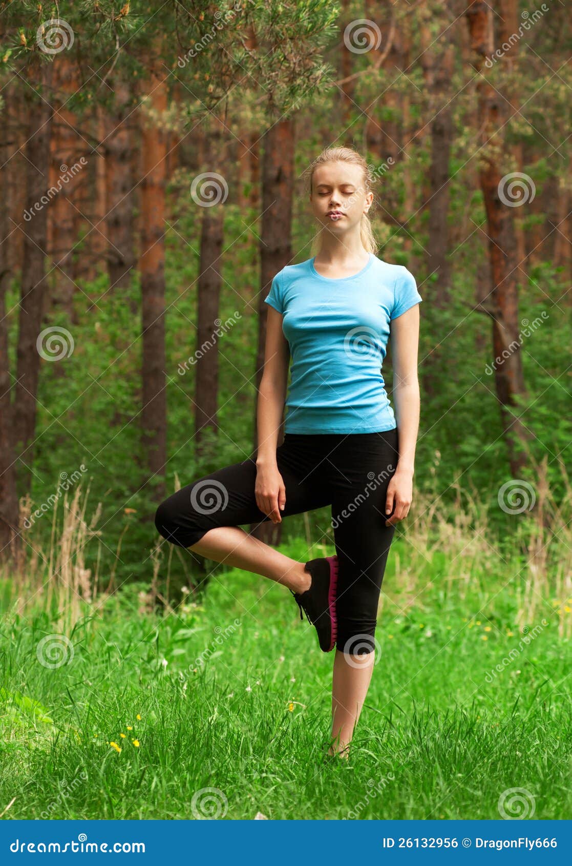 Frau, die Yogameditation tut. Junge schöne Frau, die draußen Yogameditationübung im Wald tut