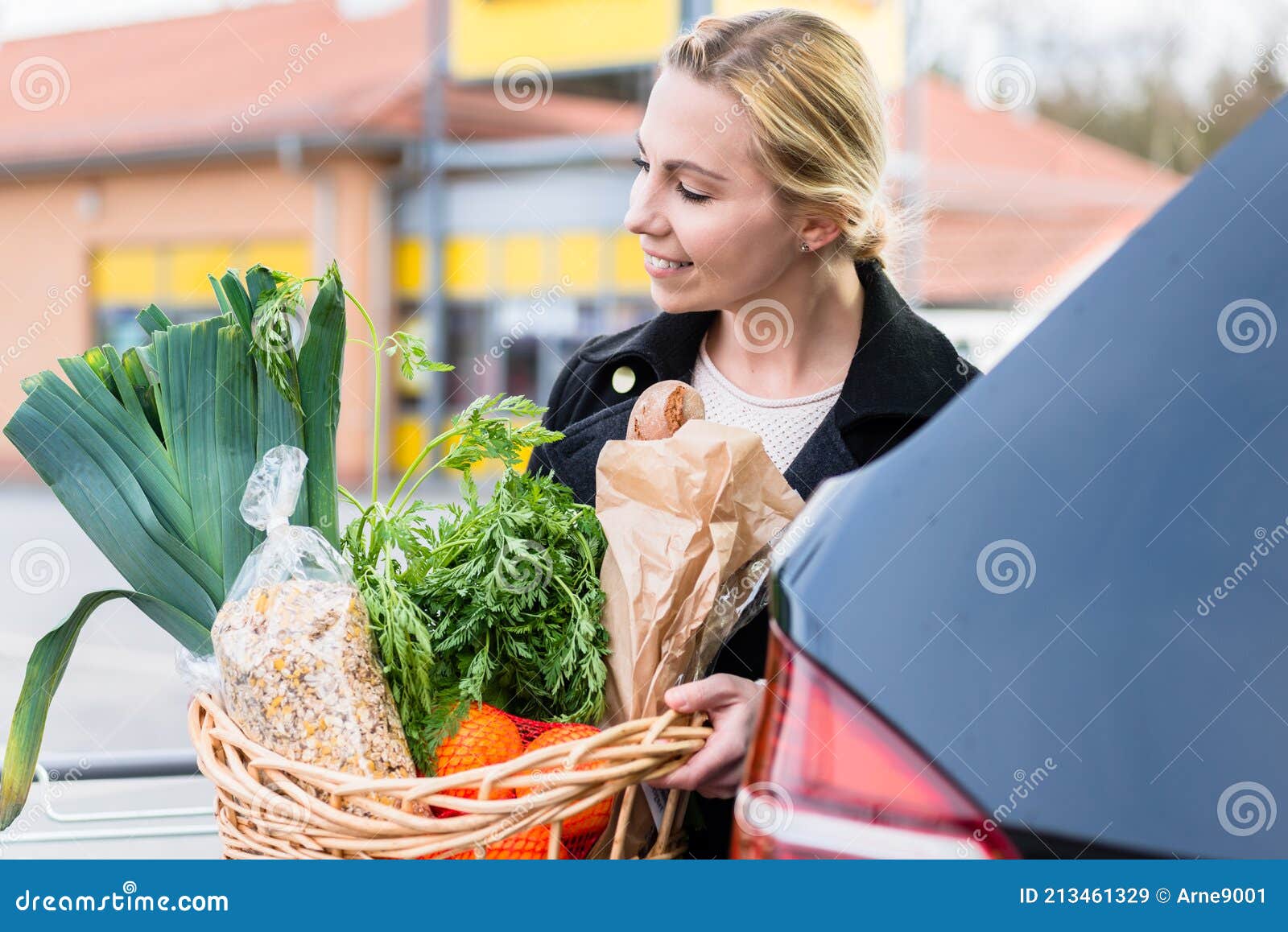 Frau Mit Einkaufskorb Mit Lebensmitteln in Den Kofferraum Nach Dem