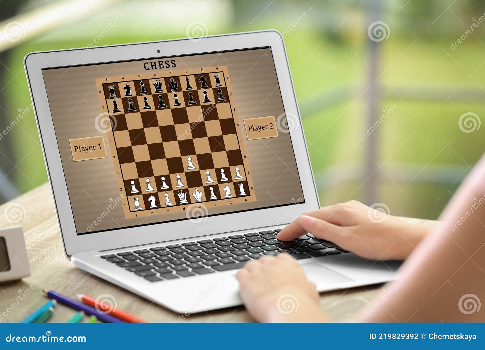 Frau Spielt Online-Schach Auf Laptop Bei Tischschließung Stockfoto