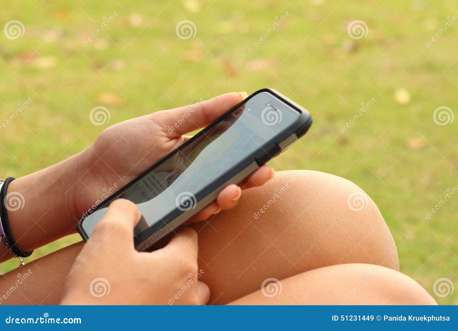 Frauen benutzt ein Telefon in einem Garten