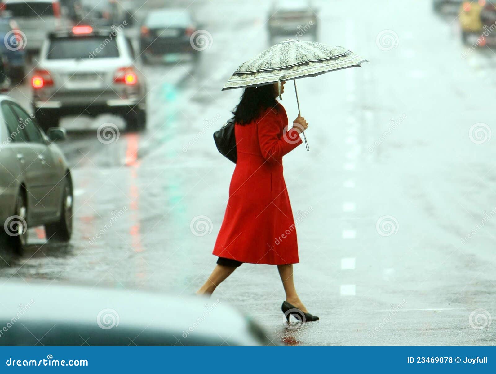 Frauen kreuzen die Straße auf dem Regen