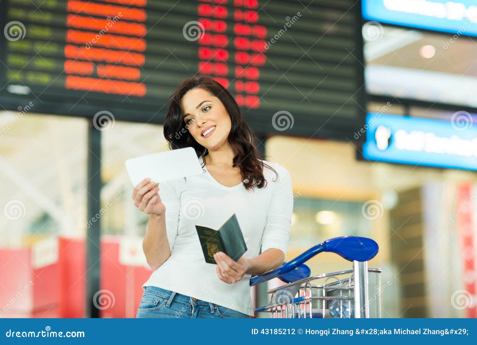 FrauenFlugticketflughafen. Lächelnde Frau, die Flugticket im Flughafen betrachtet