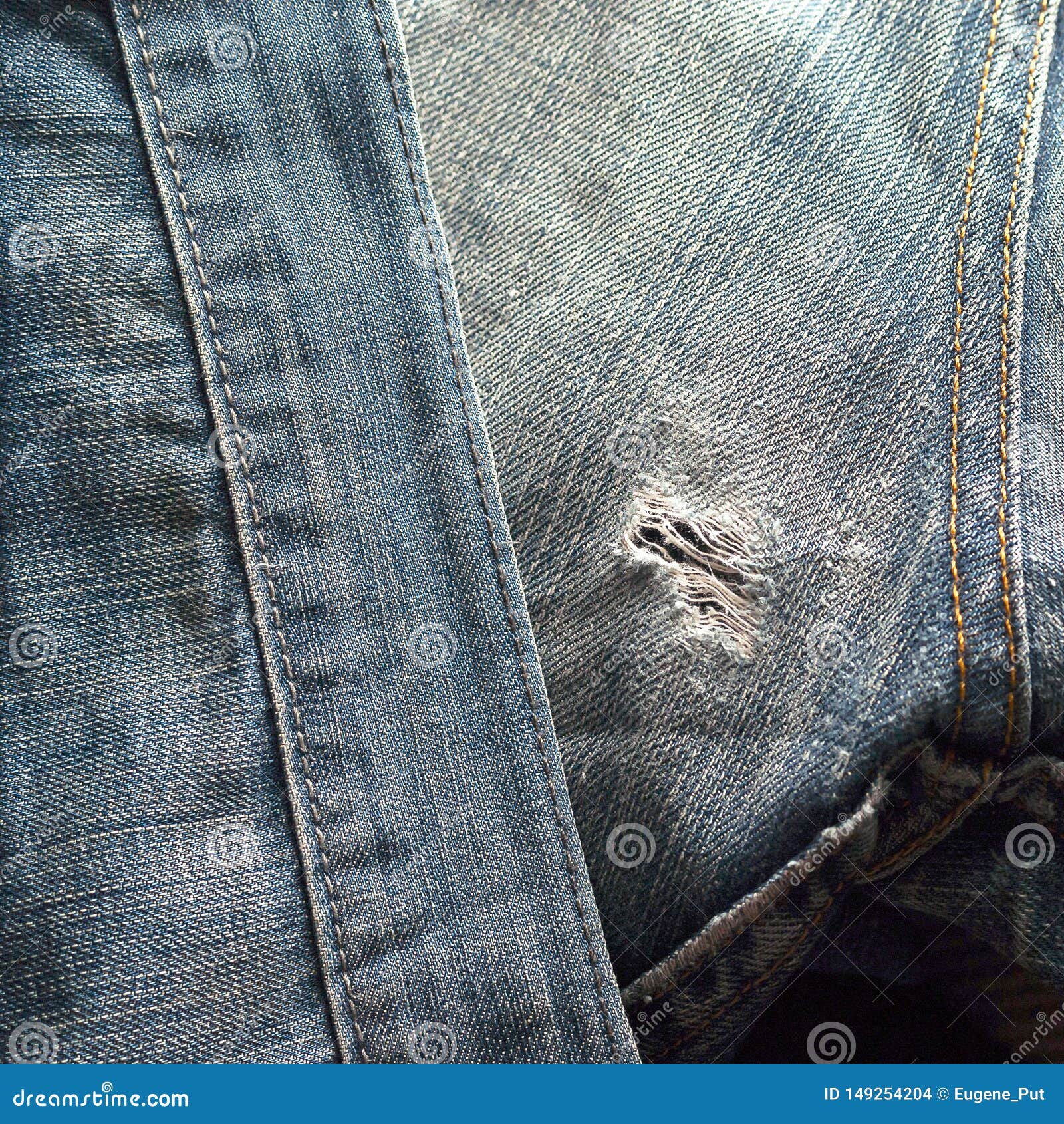 Frayed Hole on Back Side of Old Blue Jeans with Double Sewn Seams