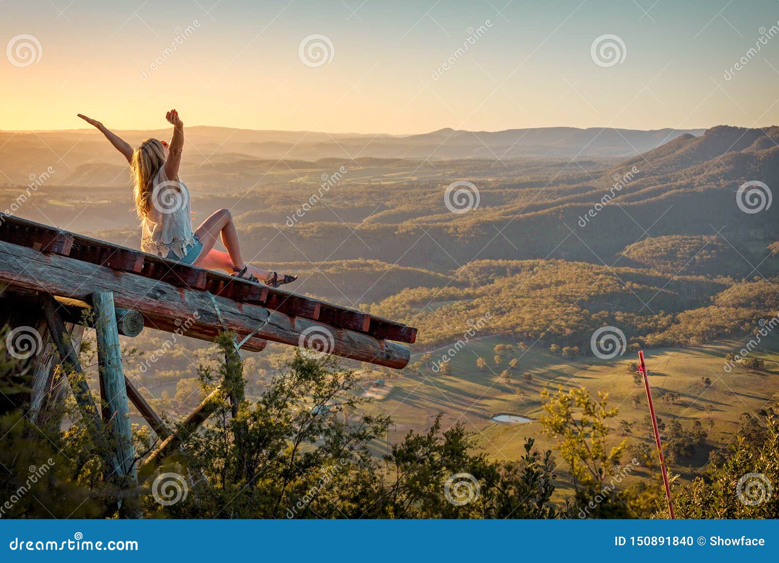 freedom loving woman feeling exhilaration on ramp high above the valley