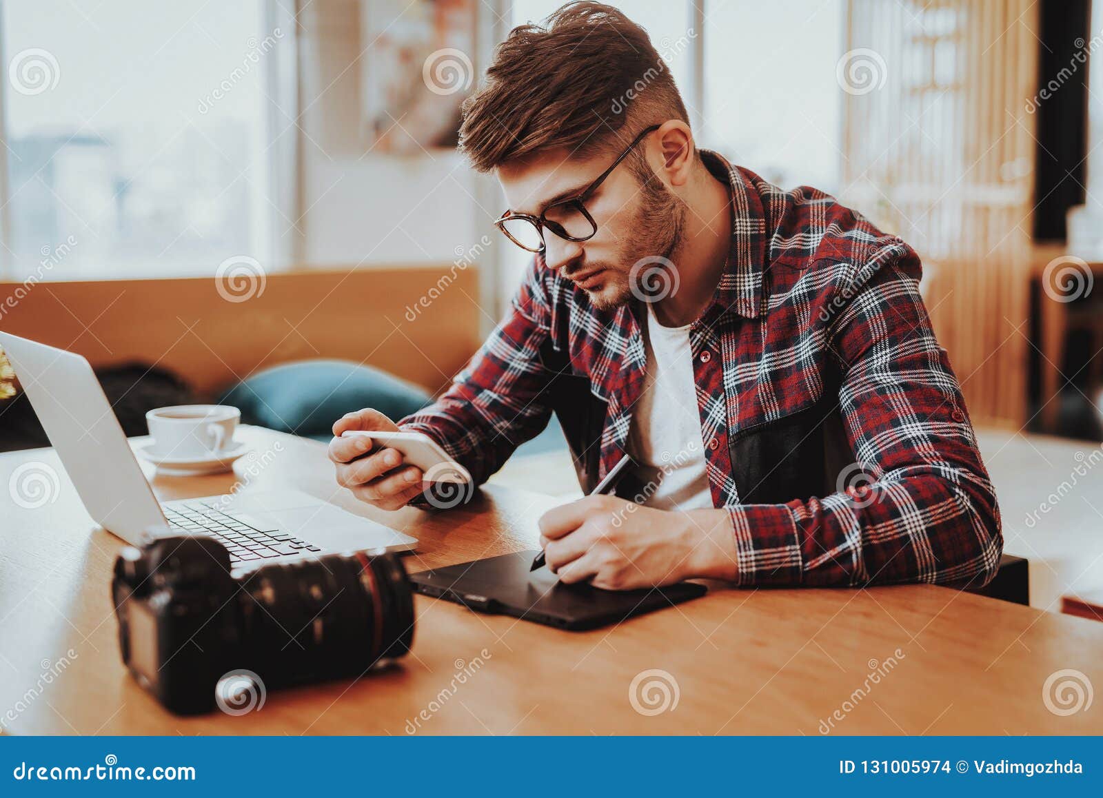 freelancer uses smartphone and working on laptop