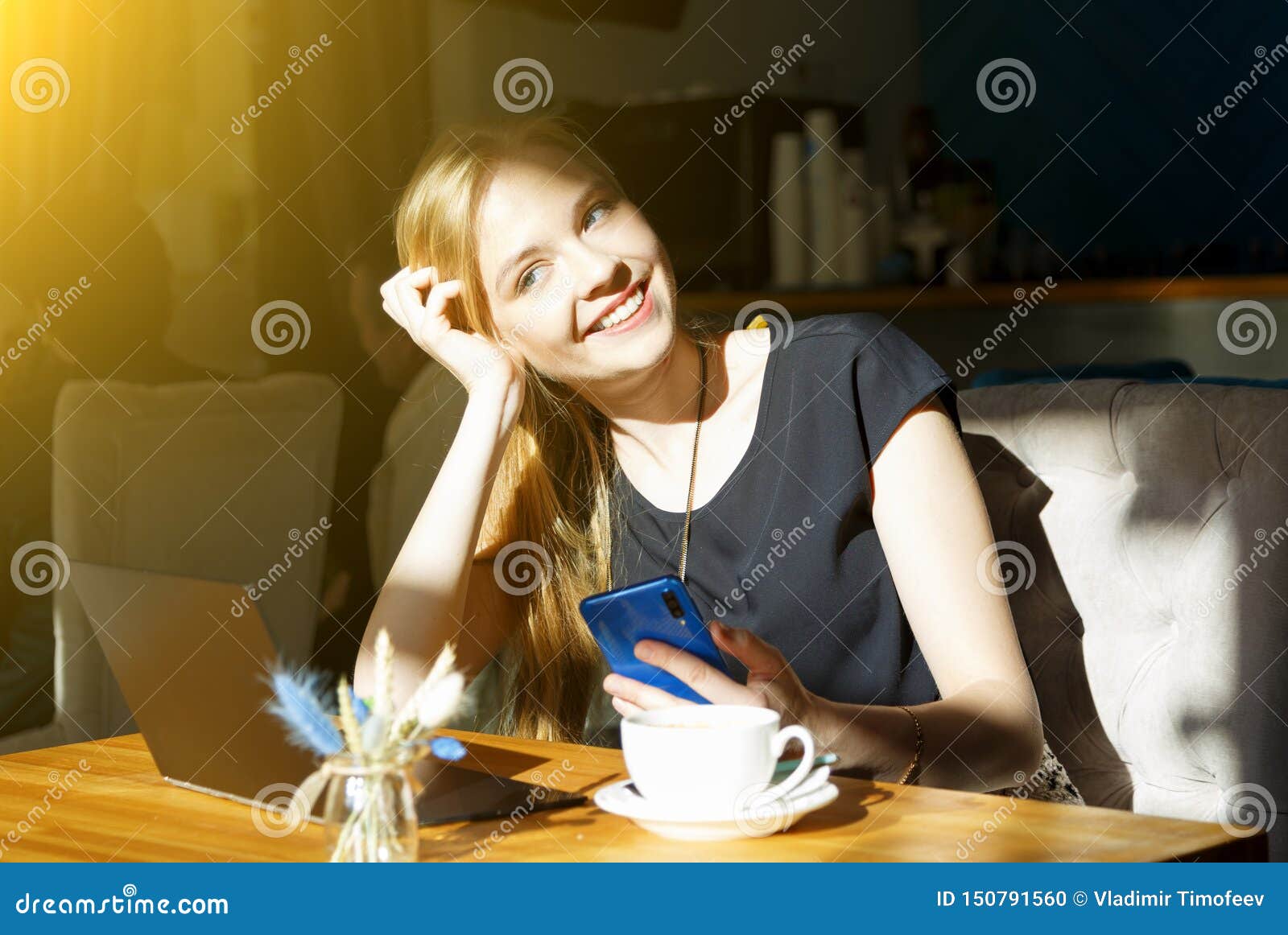 freelancer woman working online on laptop and cellphone while resting in cafe