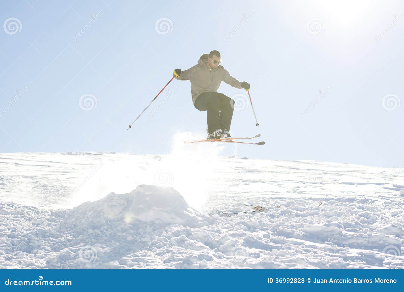 Freestyle ski jumper with crossed skis in snowy mountains