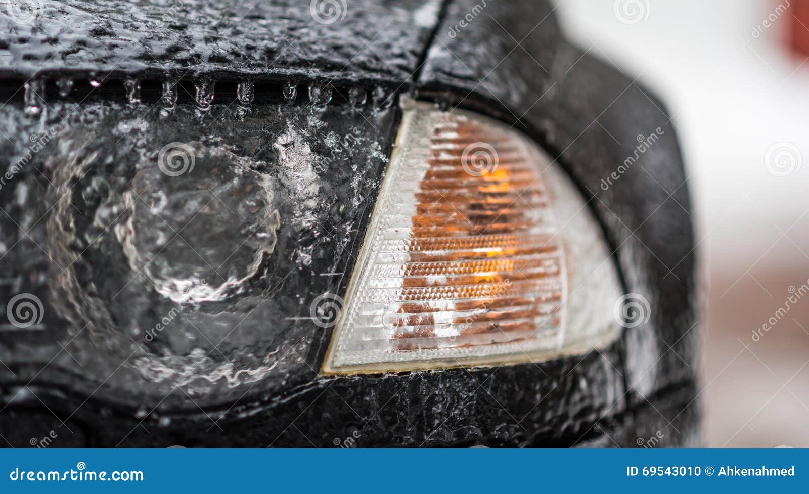 freezing rain ice coated car. headlight and signal light on black car covered in freezing rain. bad driving weather.