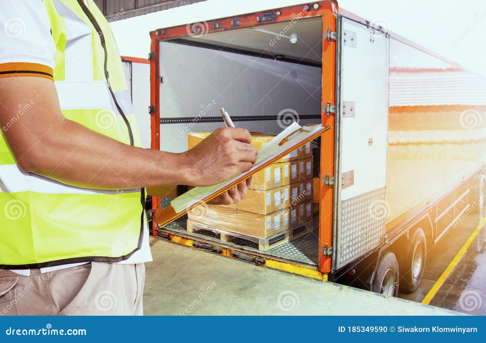 freight industry warehouse shipments transport. worker courier holding clipboard inspecting checklist load cargo into a truck.