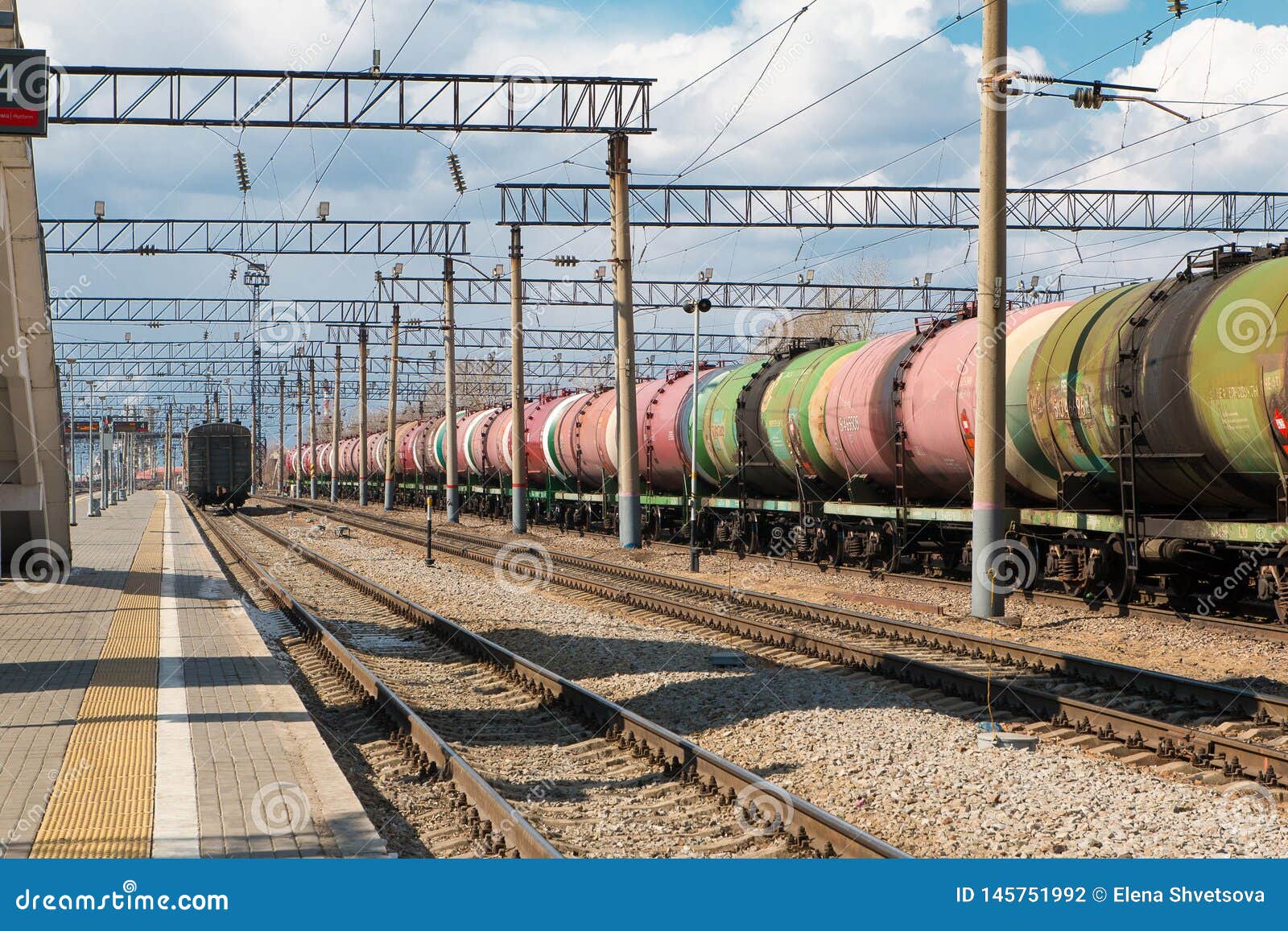 Freight Train with Tanks Stands on the Rails Next To the Building of
