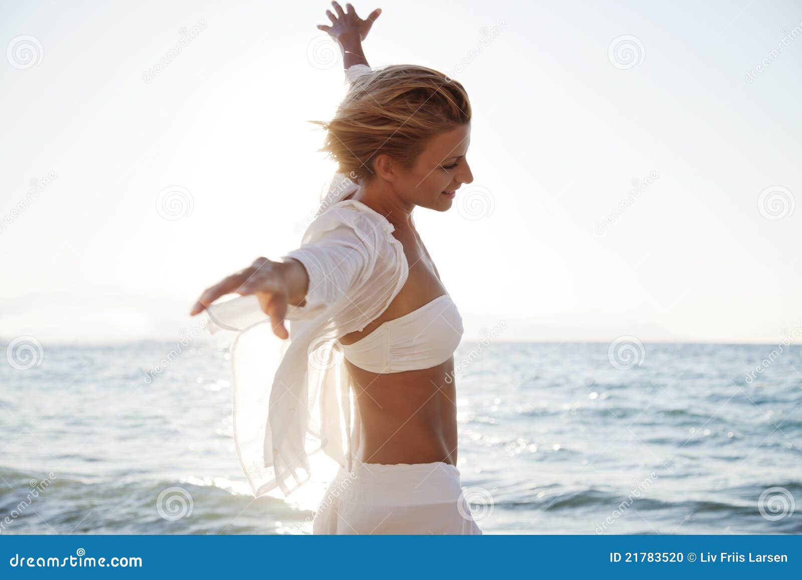 Freiheit. Sorglose junge Frau auf einem windigen Strand
