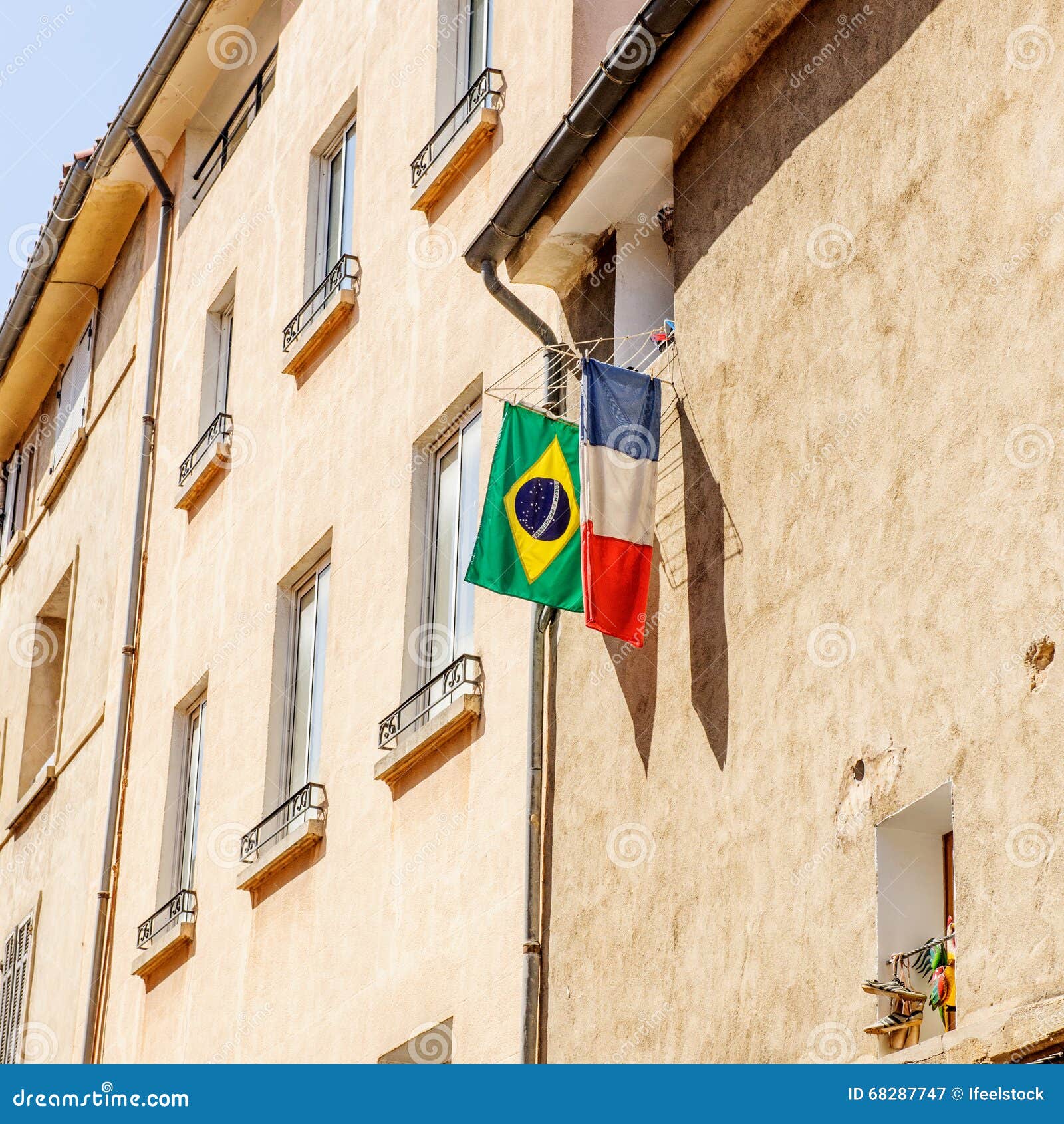 French And Brazilian Flag Hanged Outside The Window In The City