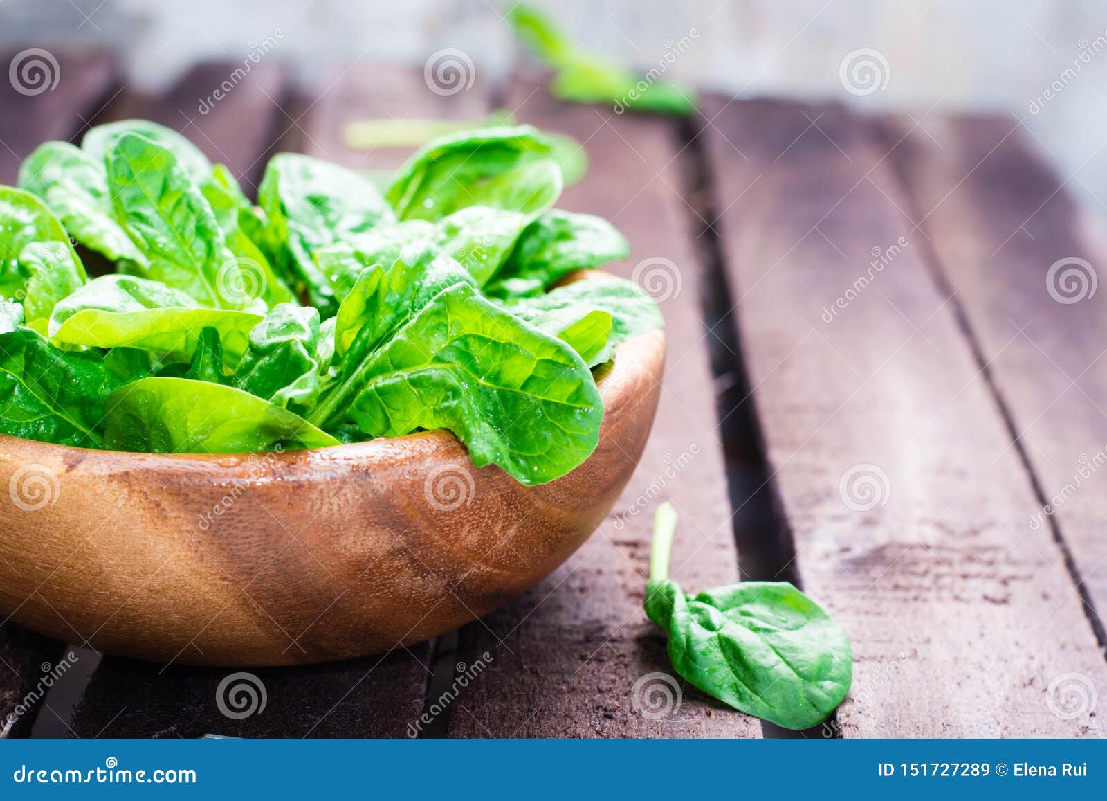 Fresh Baby Spinach Leaves in a Bowl on a Wooden Table Stock Image
