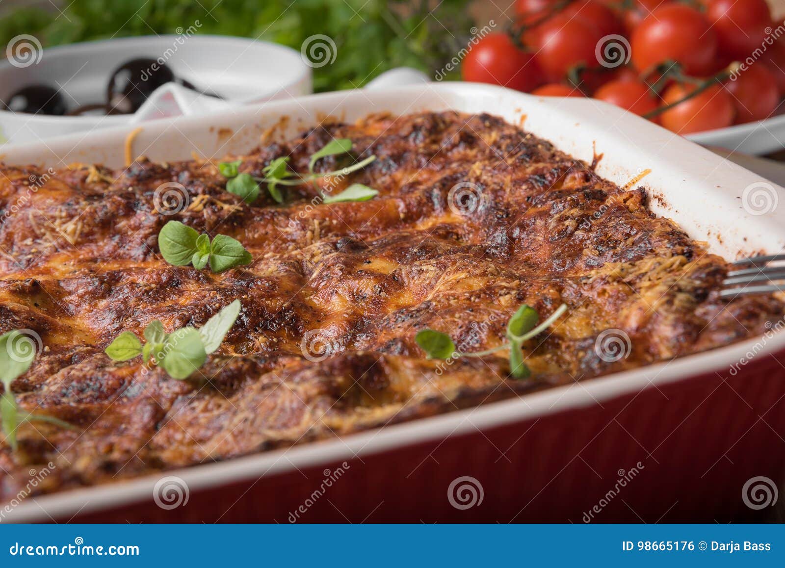 Fresh Baked Lasagne In Red Dish With Black Olives Tomatoes And Chilli ...
