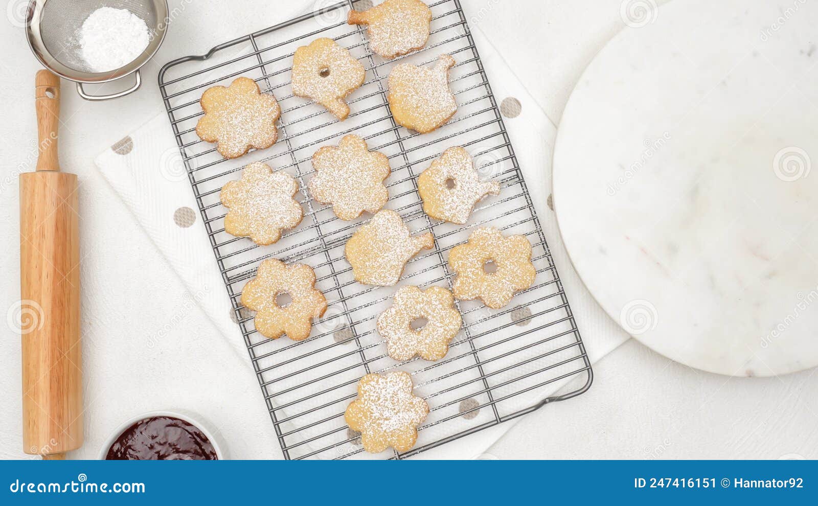 fresh baked shortbread cookies on a cooling rack. topping cookies with powdered sugar