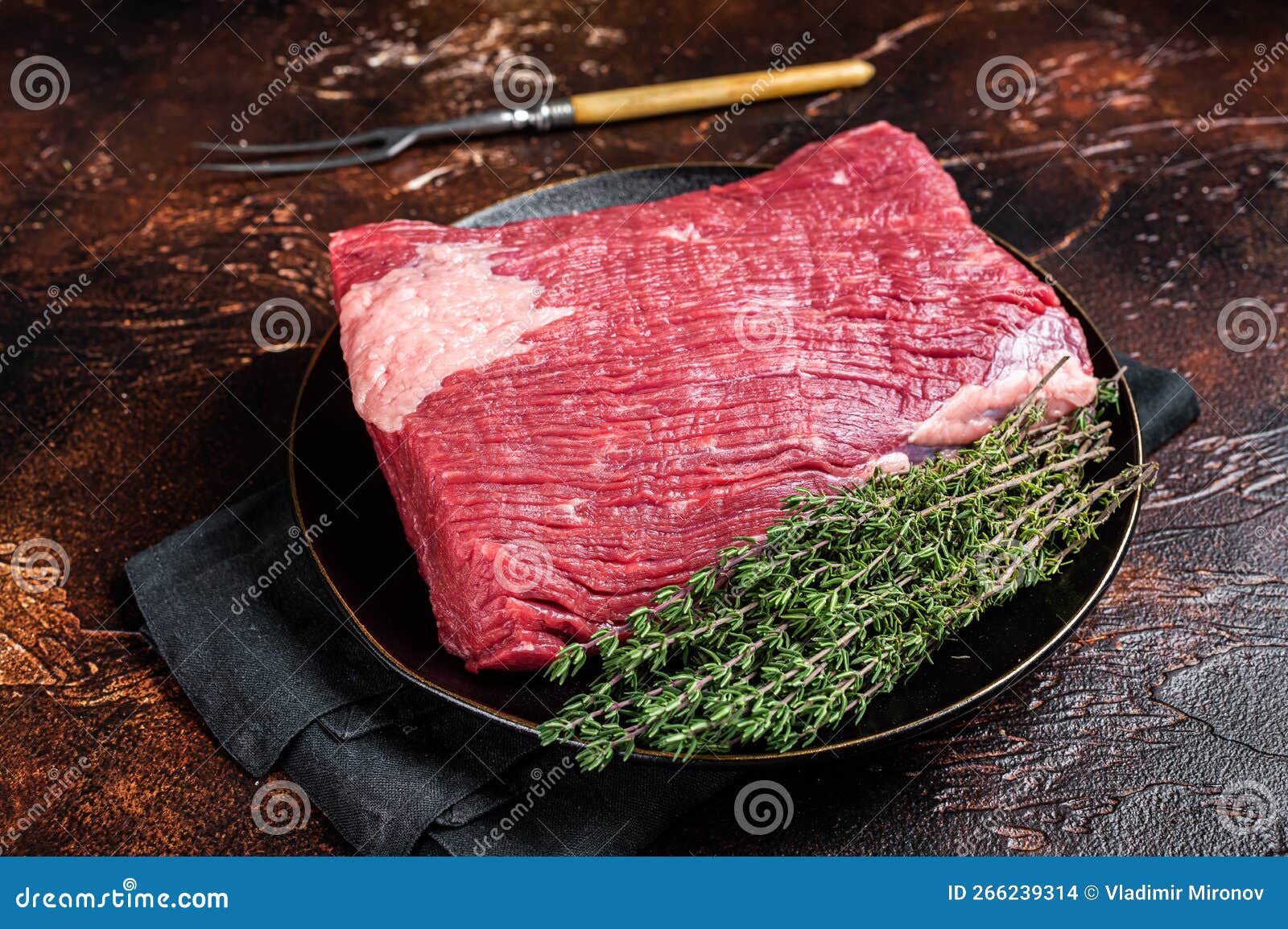 Fresh Beef Brisket, Raw Meat with Herbs. Dark Background Stock Photo