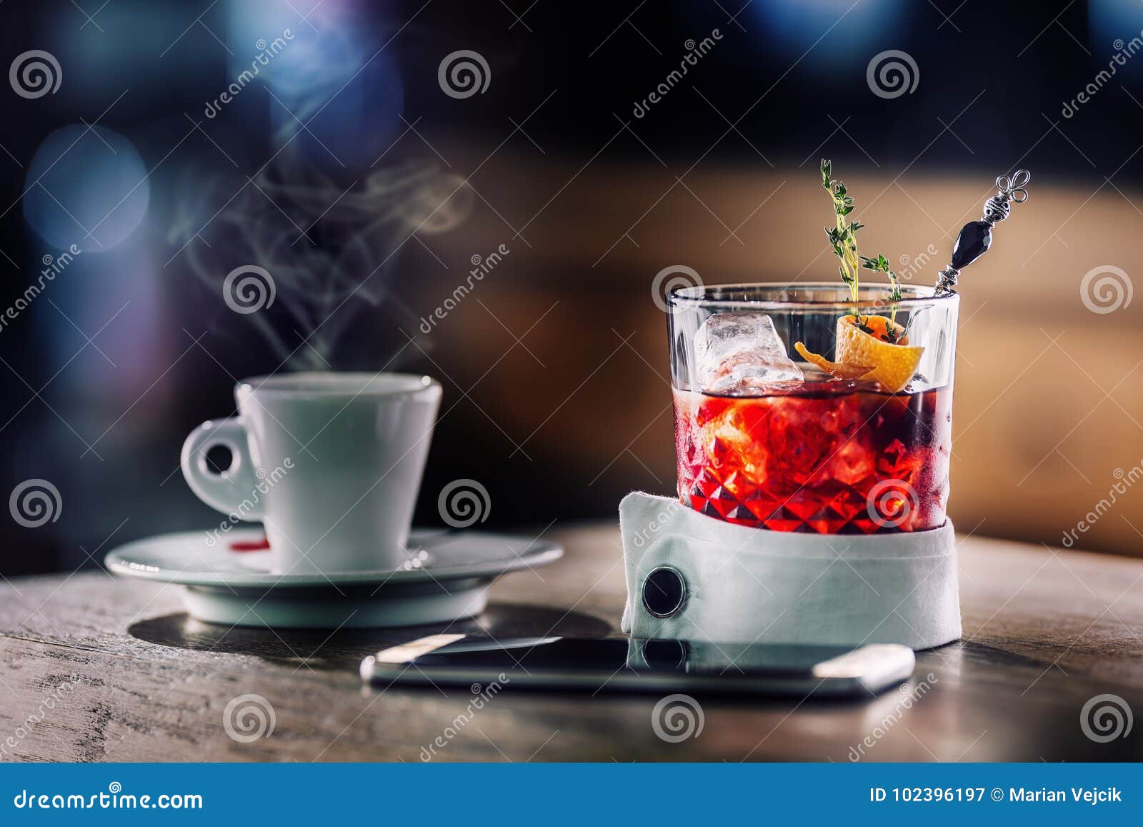 fresh cocktail drink with cup of coffee and smartphone. alcoholic, non-alcoholic drink-beverage at the bar counter in the pub.