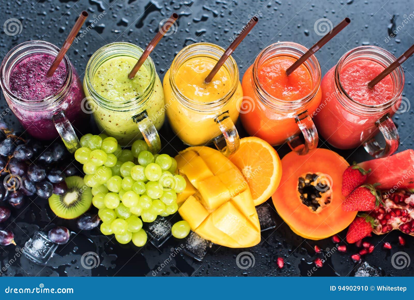 Isolated juices. Glasses of fresh juice and pile of tropical